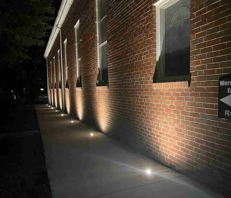 Wall wash hardscape lighting highlighting a brick building exterior in Raleigh, North Carolina